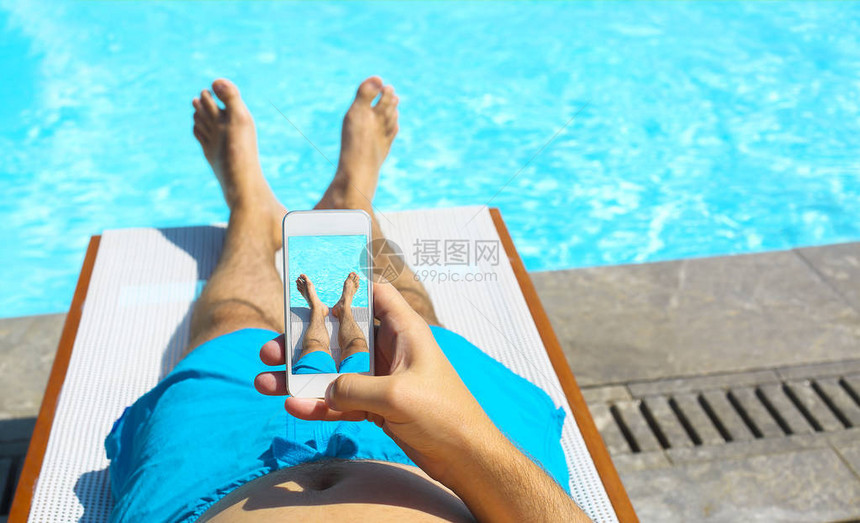 年轻人躺在泳池附近的阳光下带图片