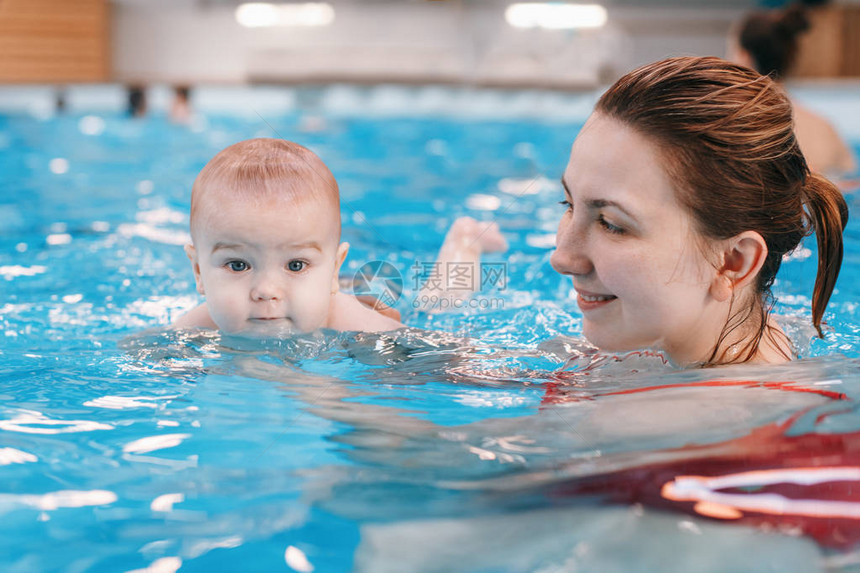 白种人母亲正在训练她刚出生的婴儿漂浮在游泳池里婴儿在水中潜水健康积极的生活方式活动和图片