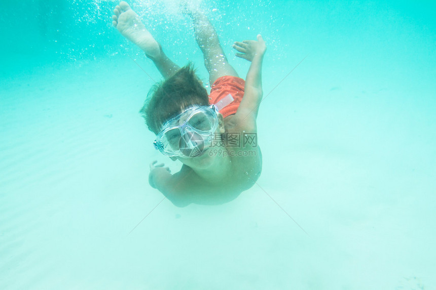 小男孩的水下肖像戴着面具浮潜图片
