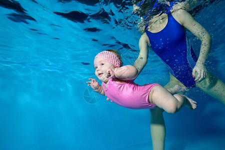 一个小女孩在游泳池里游泳图片