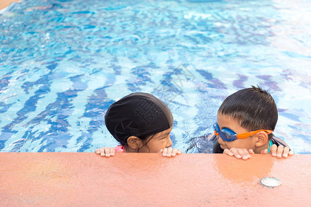 小男孩和女孩在游泳池里游泳图片