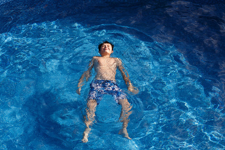 在花园游泳池的年轻少年男孩图片