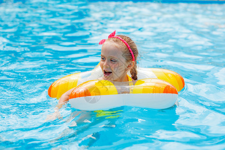 可爱快乐的小女孩在游泳池玩得开心的肖像图片