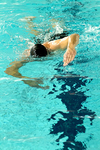 人游在泳池的车道上游泳代表健康图片