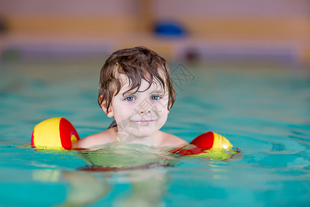金发小男孩在室内游泳池游泳的肖像适合儿童的图片