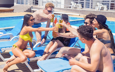 一群开心的朋友在游泳池的派对上喝鸡尾酒和啤酒图片