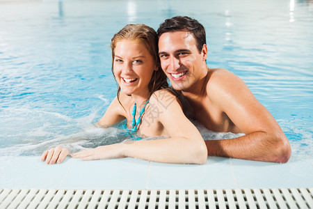 在游泳池享受水力按摩的幸福夫妻图片
