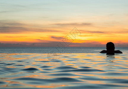 在日落时俯视海洋的无尽游泳池边缘图片