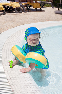 小男孩在游泳池里玩水图片