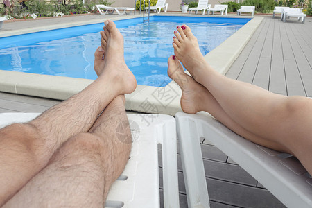 一对夫妇躺在游泳池旁的图片