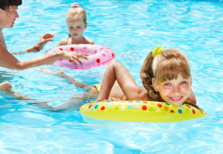 家庭快乐孩子们坐在游泳池的充气环上图片