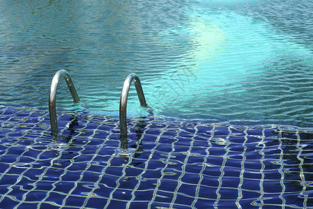 清空的户外蓝泳池带金属银制脚图片