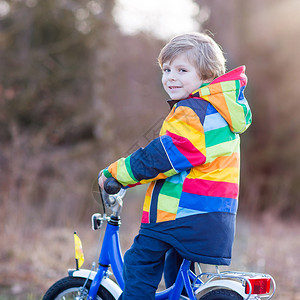快乐的小男孩在自行车上户外的肖像图片