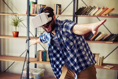 年轻的高加索男子使用现代VR头目眼镜在虚背景图片
