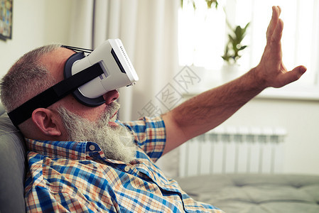 白种老人使用现代虚拟现实耳机眼镜非常兴图片
