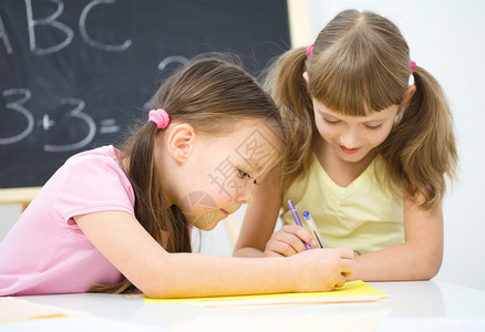 可爱的小女孩在学龄前用钢笔写字图片