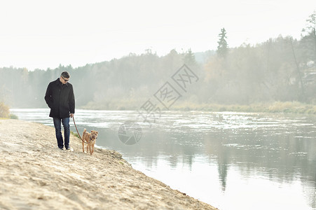男人在河边遛狗图片