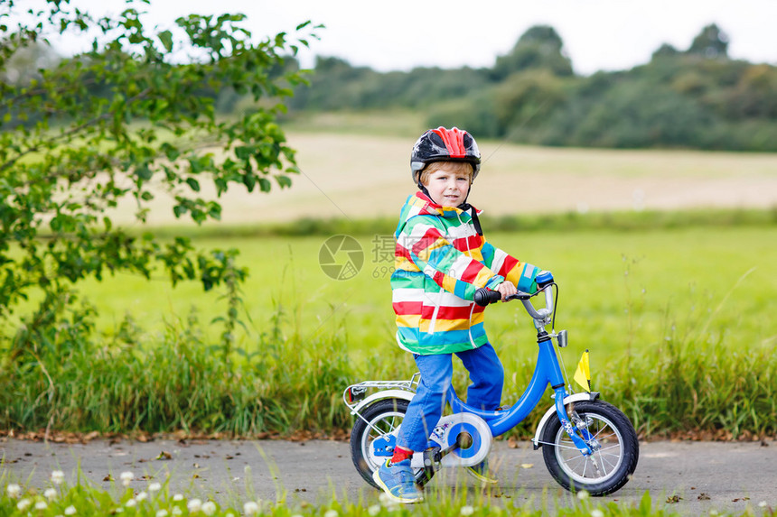 有趣的活跃小男孩在温暖的夏日骑自行车农村戴头盔的孩子为孩子们提供积极图片