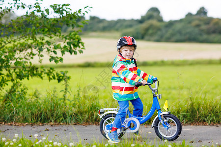 有趣的活跃小男孩在温暖的夏日骑自行车农村戴头盔的孩子为孩子们提供积极图片