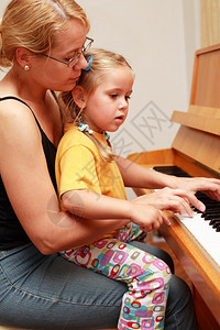 母亲和女儿弹钢琴背景图片