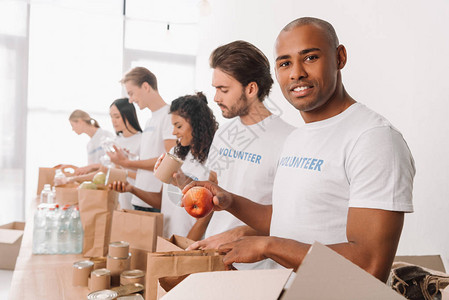 African美国志愿人员将食品包装在与穆里族同图片