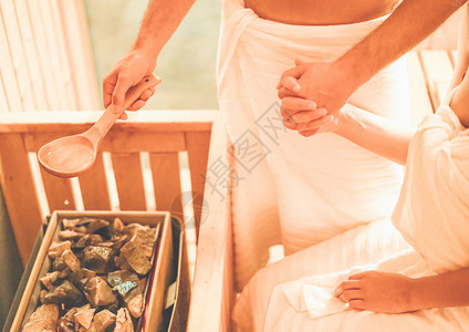 年轻夫妇手牵在温泉度假酒店的桑拿浴室放松图片