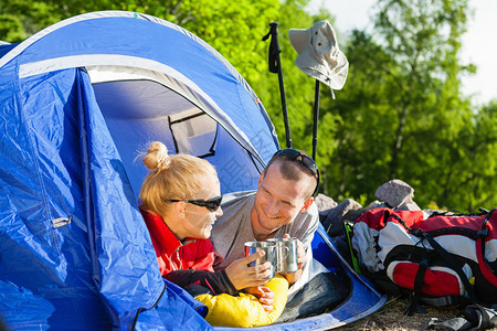 快乐的年轻搭便车的夫妇在帐篷里露营图片