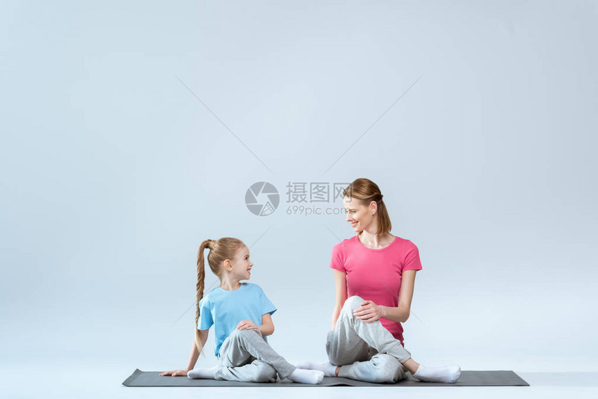 微笑运动的母亲和女儿在做哥穆哈萨纳瑜伽时图片