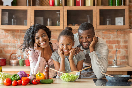可爱的Afro家庭在厨房一起烹饪健康晚餐图片