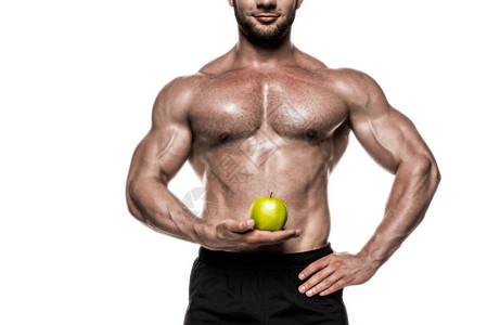 将绿色苹果孤立在白色健康饮食概念上的汗水运动健美肌肉运动员的图片