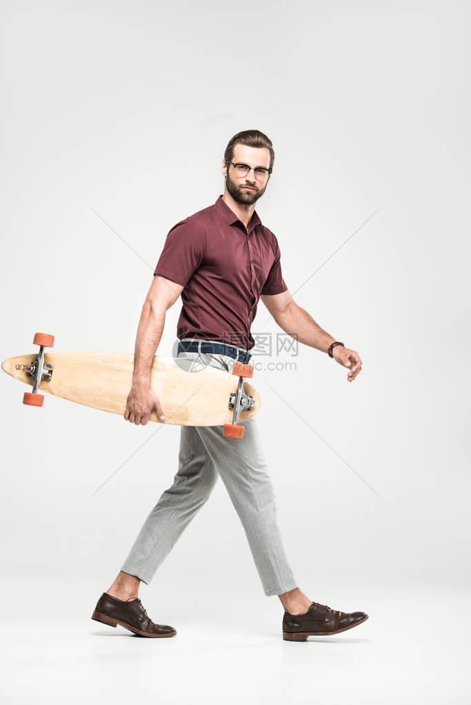 身着长板的帅滑板车手在灰图片