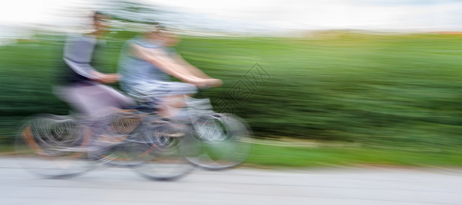 两名青少年骑自行车在城市公路上行驶故意图片
