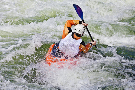 活跃的男Kayaker滚动和冲图片