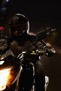 男人晚上骑摩托车在北京街上图片