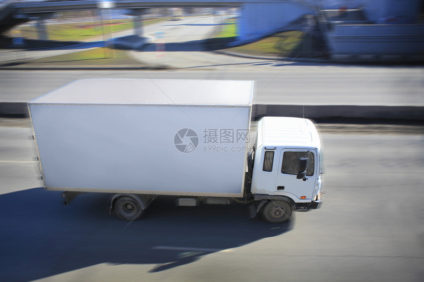 在城市街道上行驶的白色卡车图片