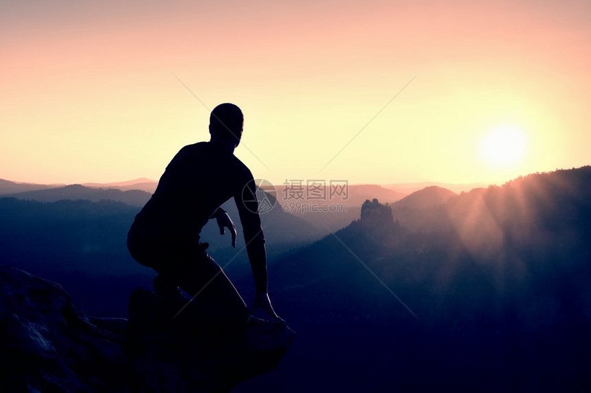 日落时山风景中高的男徒步旅行者山上夜晚美图片