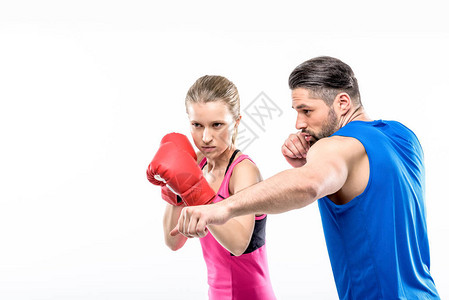 女孩和她的私人训练员一起练习拳击在背景图片