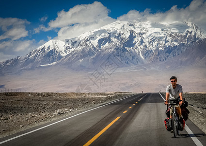 卡拉库鲁姆高速公路骑自行车的单身男骑自行车者Karak图片
