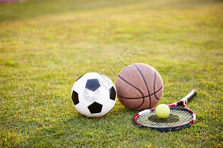 日落时躺在草地上的足球篮背景图片