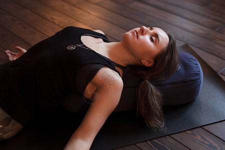 在沙瓦萨那的瑜伽课后休息的女人脊椎治疗图片