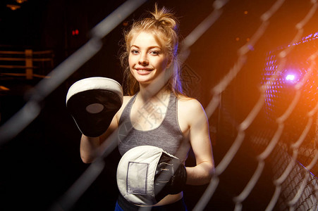 年轻女运动员戴拳击手套黑色背图片