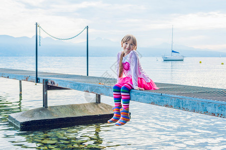 一个坐在码头上可爱小女孩图片
