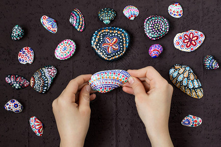 在海卵石和贝壳上手绘彩色圆点图案图片
