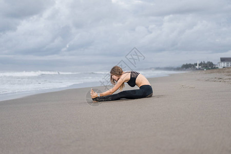 迷人的年轻女子在卡特比勒做瑜伽在图片