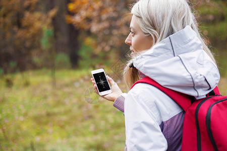 女在森林里用智能手机检查图片