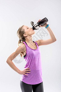 运动型金发女子从运动瓶中喝水图片