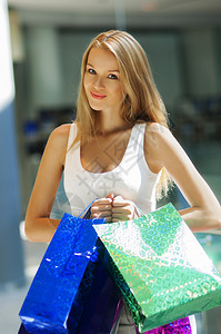 美女在购物中心拿着袋背景图片