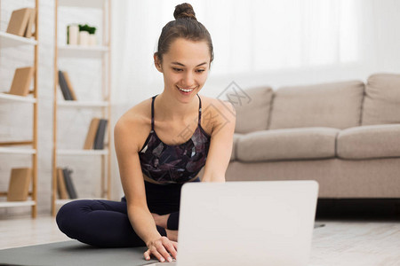 在线瑜伽辅导女使用笔记本电脑在家图片