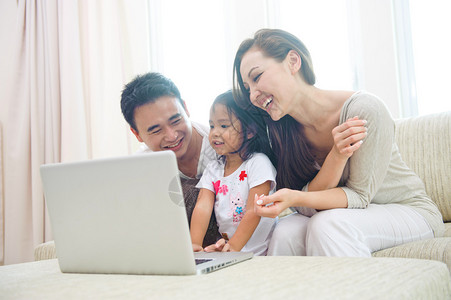 亚洲幸福家庭使用笔记本电脑与dau图片