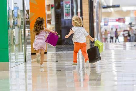 孩子们购物可爱的小女孩和男孩在购物购物袋图片